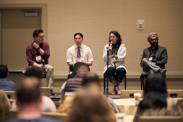 Four panelists in conversation on stage