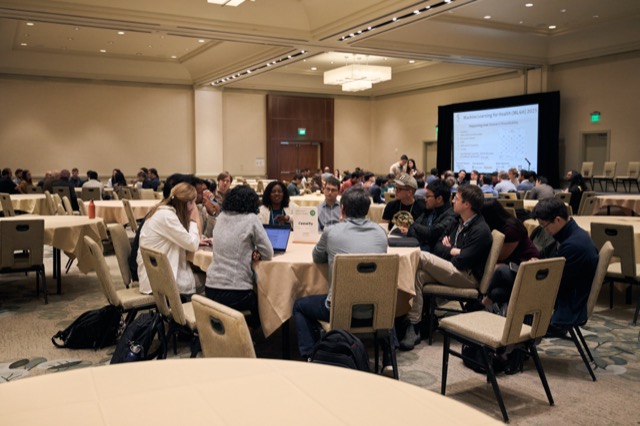 Attendees in discussion at round tables